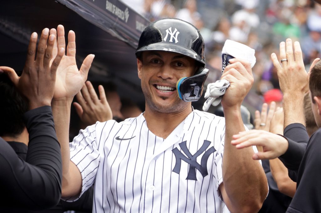 Der von den Yankees designierte Giancarlo Stanton (27) empfängt auf der Trainerbank, nachdem er in der ersten Halbzeit gegen die Cubs im Yankee Stadium am Sonntag, den 12.